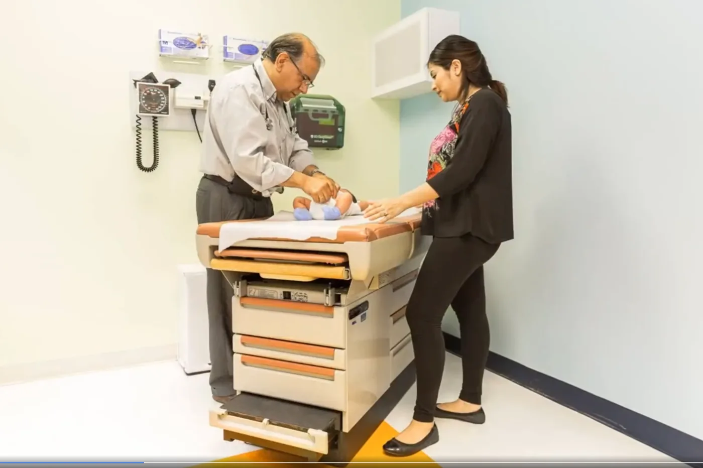 A pediatrician listening to a child's concerns during a visit