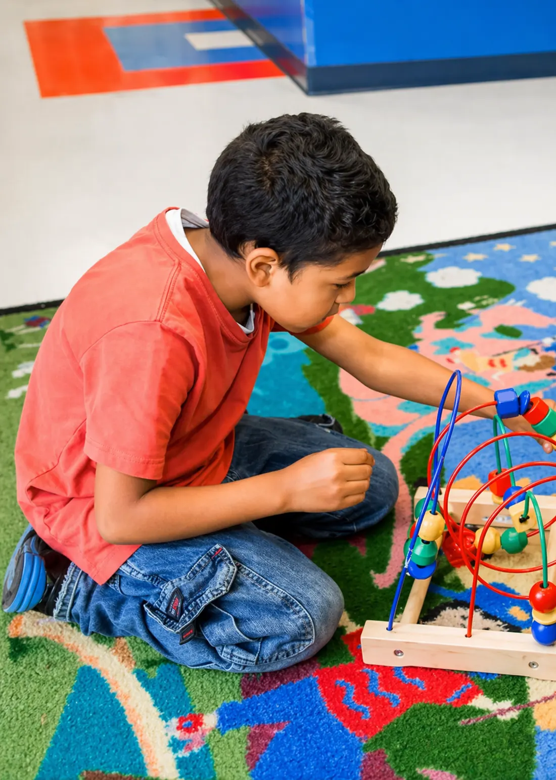 A young patient focused on a bead maze in the AAA Pediatrics waiting area