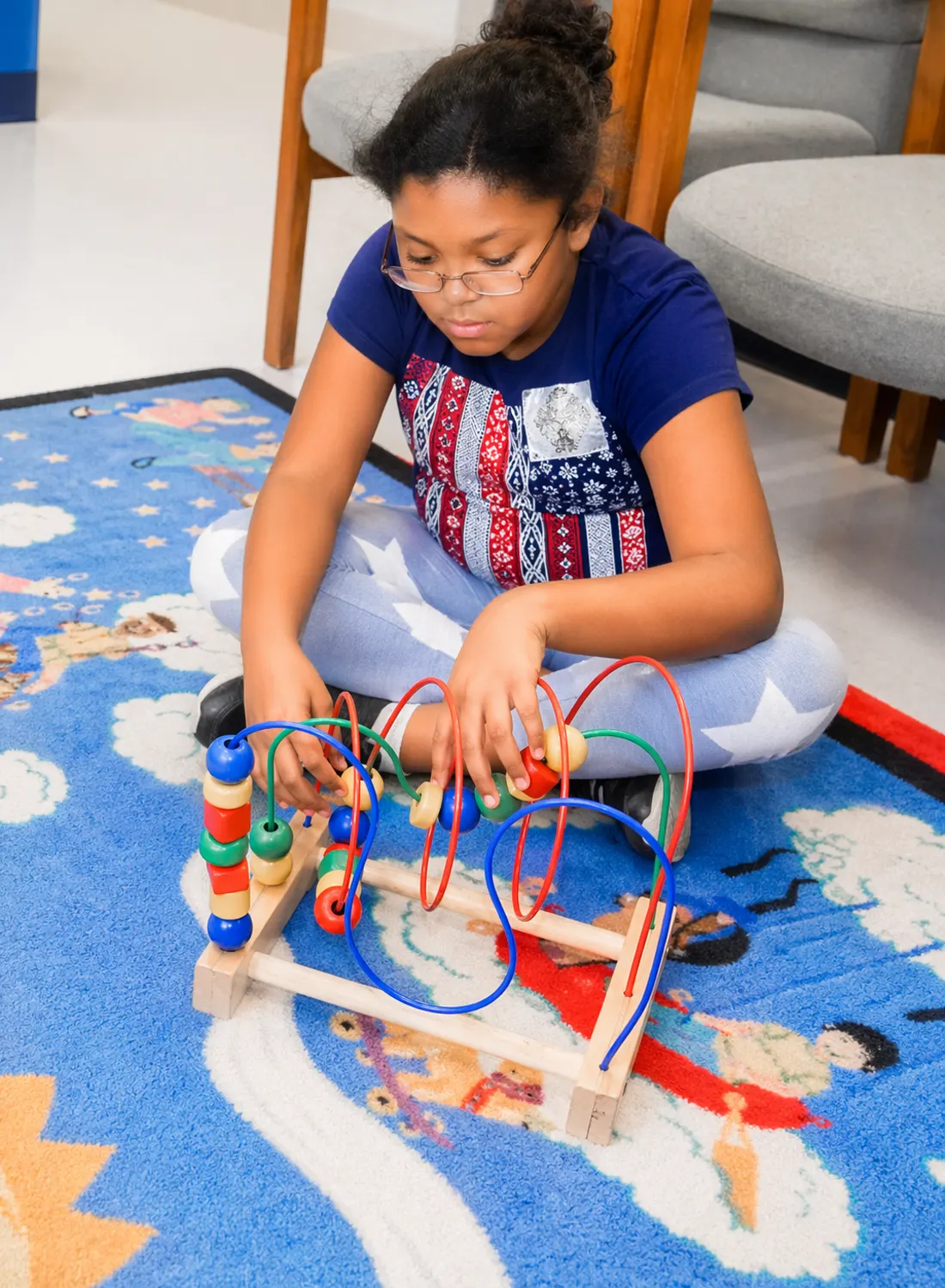A young patient enjoying a bead maze in the AAA Pediatrics waiting area